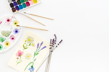 Drawing flowers with watercolor paintis on white background top-down frame copy space