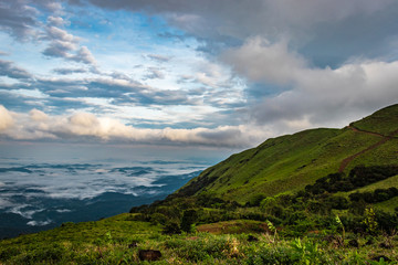 Cloud layers on mountain horizon with green grass