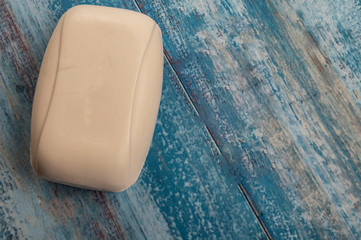 A piece of toilet soap on a wooden background. Frequent hand washing with soap is a prevention of COVID-19 infection. Close up.