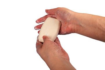 Someone is soaping their hands with a piece of toilet soap. Frequent hand washing with soap is a...