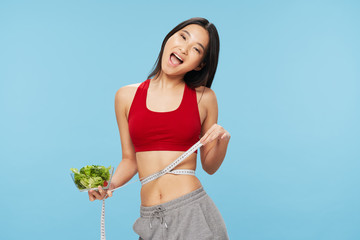 young woman measuring her waist