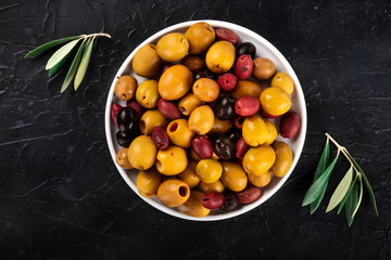 Olives variety. Black, green and red olives, shot from the top on a black background with copy space