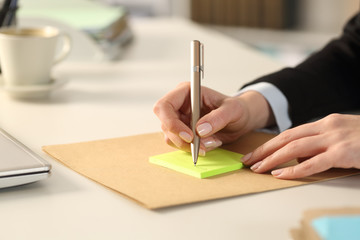 Executive hands writing on sticky notes at the office
