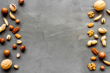 Nuts background - with almond, macadamia, walnut - on grey table top-down frame copy space