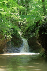 Fototapeta na wymiar Waterfall on a mountain river in spring