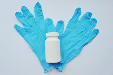 Blue medical gloves and a white jar isolated on white background.