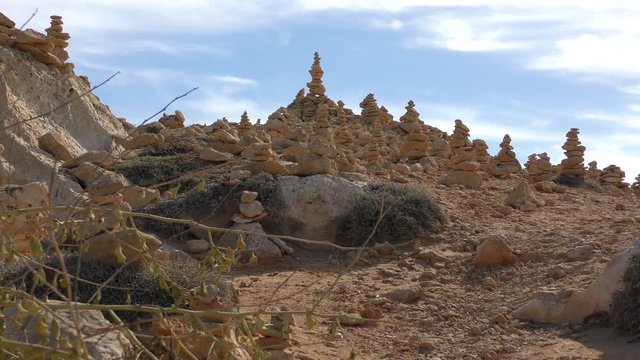 Bright blue sky, beautiful day. Pyramids made of stones on a low stone hill. Filmed on the territory of the park Royal Tombs, near Paphos, Cyprus. The Tombs of the Kings is a large necropolis. 