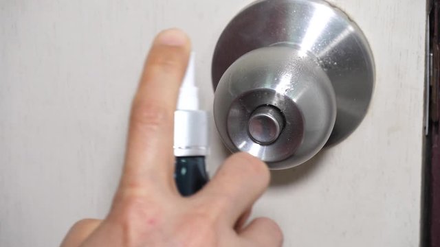 People use alcohol spray for sterilize on doorknob and wipe by tissue towel before open in covid-19 endemic, hygienic care in for avoid from corona virus plague, reduce sickness disease in spread time