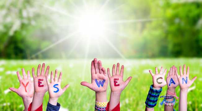 Children Hands Building Colorful Word Yes We Can. Green Grass Meadow As Background