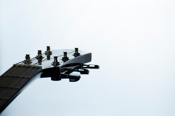 Macro elements of an acoustic guitar on a light background in monochrome.