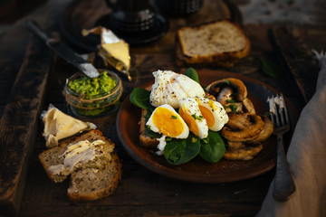 Appetizing breakfast boiled egg, toast, cheese and mushrooms in a clay plate on a wooden background. medium cooked egg