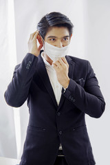 Young Asian businessman is wearing a mask at workplace to prevent the epidemic  corona virus, white background