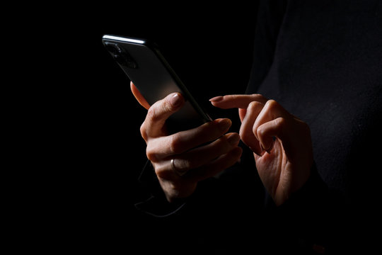 Person Holding In Hands And Typing On Mobile Phone, Photo Isolated On Black Background