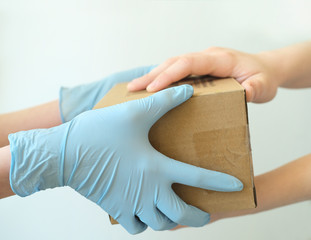 Delivery man holding cardboard boxes in medical rubber gloves. Fast and free Delivery transport . Copy space. Online shopping and Express delivery. Close-up. White background