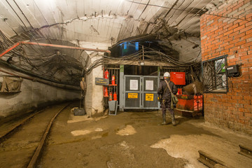 Fototapeta na wymiar Shaft bottom lodge cage with light in underground mine
