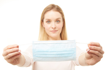 Beautiful blond woman holding a face mask