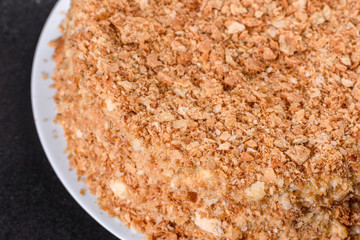 Fresh delicious cake napoleon with cream on a dark background