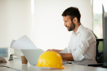 Businessman in office. Handsome man working on project. 	