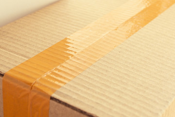 brown carton paper box package with packing scotch tape stick