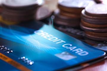 Close up of credit card shot and coin stack with selective focus.