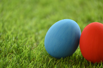 Fototapeta na wymiar red and blue easter egg on lawn green grass artificial, concept image of morning in springtime