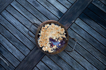 freshly baked apple blueberry crumble on a rustic wooden table