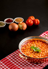 traditional turkish food dried beans on a copper plate with vegetables next to it