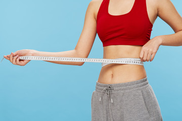 young woman measuring her waist