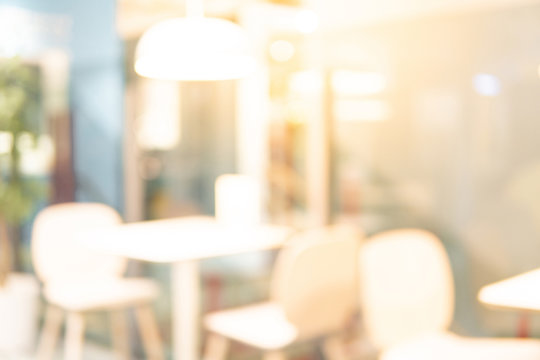 Abstract blurred restaurant background. Blurry cafe or coffee shop with dining tables, chairs and other decorations. Blur backdrop for design element. Food and beverage concept.