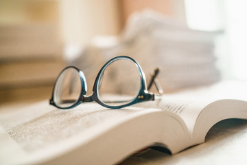 Eyeglasses on a book. Reader's or Student's tired in the calssroom concept.