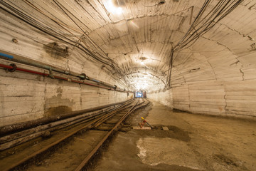 Underground gold mine tunnel with rails and light