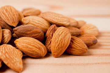 Almonds nuts shot large on a wooden background. Background for healthy eating and vegetarianism.