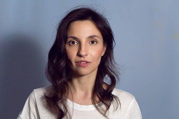 Fototapeta premium portrait of a brunette girl on a blue background