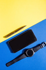 Flat lay composition for freelance blogger. Workspace with pen, stylish smartphone, black watch on colorful background.Business concept. Modern lifestyle.