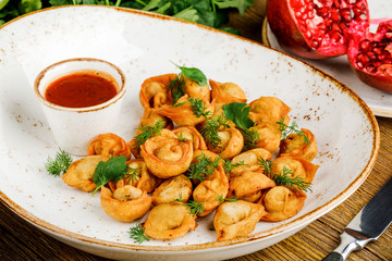 plate with fried pelmeni and sauce. russian cookery