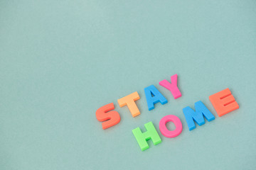 The inscription stay home from plastic letters on a paper background