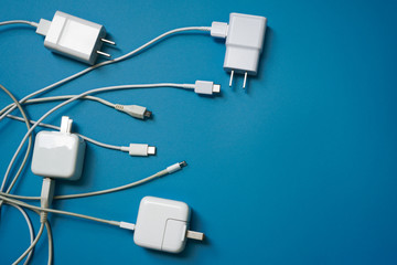 Top view or flat lay of White mobile power charger and USB in multiple types laid disorderly and...