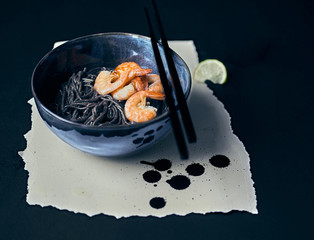 Chinese noodles with seafood on a dark background