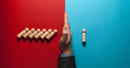 Hand of businessman stops falling figures of people (employees) on red and blue background. Finance...