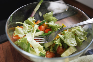 fresh vegetable salad in transparent bowl with fork