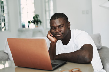 A man of African appearance in front of a laptop