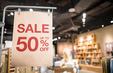 Discount percentage sign display in  fashion department store during sale season period.