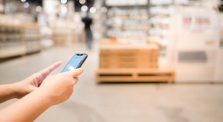 Female hands holding smart phone with online shopping screen  or information content, smartphone...