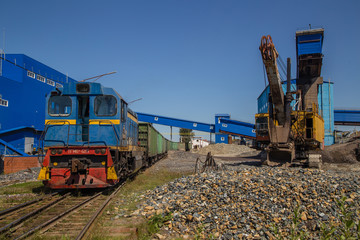 Freight train on railway railroad and excavator power shovel on the mining site 