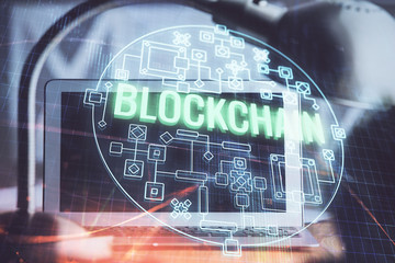 Multi exposure of blockchain and crypto economy theme hologram and table with computer background....