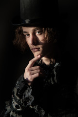 Fototapeta na wymiar The young man in a top hat, tailcoat, lace. Portrait. Boho.