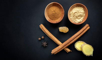 Fototapeta na wymiar Composition of cinnamon and ginger on a black background. The concept of healthy nutrition, protection from viruses at home, increased immunity during coronavirus quarantine, super nutrition.