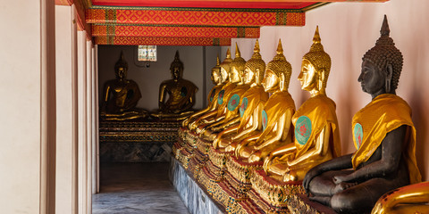 Fototapeta premium A row of Golden statues in a Thai temple