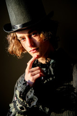 The young man in a top hat, tailcoat, lace. Portrait. Boho.