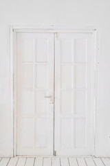 Old-style white wooden door. interior apartment. Wooden floor made of planks